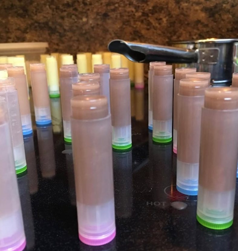 Rows of lip balm tubes being filled