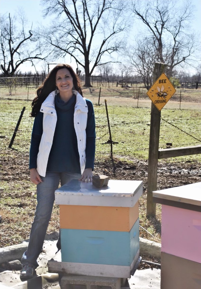 Toni Pounds standing beside her bee hives